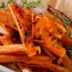 Golden sweet potato fries cooling from the oven