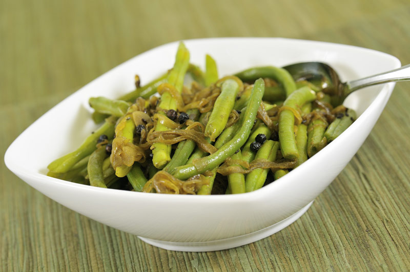 Tasty green beans steamed to pefection is a white bowl