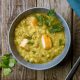 Tasty split pea soup in a gray bowl, sprinkled with fresh parsley