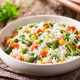 White rice with carrots, peas and veggies cooked to perfection on a plate
