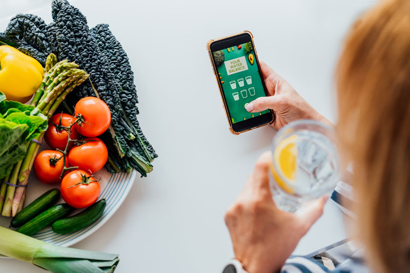 Woman loading app to track her water and calorie intake post-hysterectomy